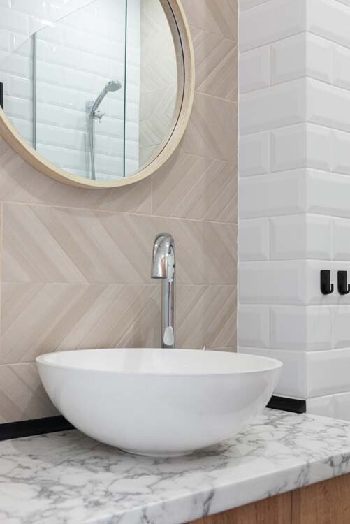 Beige wandtegels gecombineerd met witte metrotegels in badkamer